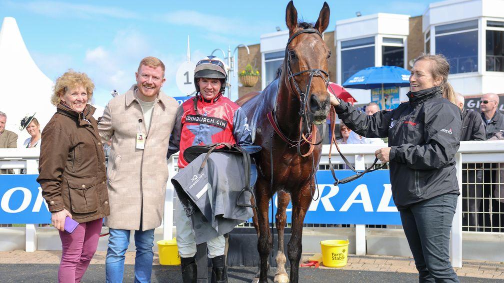 Joe Bunch is all smile between trainer Lucinda Russell and jockey Derek Fox after Primoz carried his colours to victory
