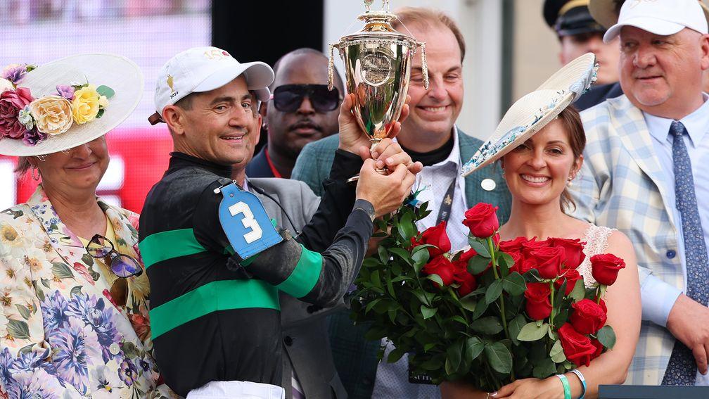 Kenny McPeek (right) looks on as Brian Hernandez and Mysik Dan's connections celebrate with the Kentucky Derby trophy
