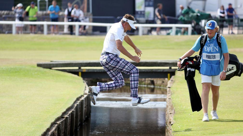 Ian Poulter leaps over a water hazard during a practice round at St Andrews