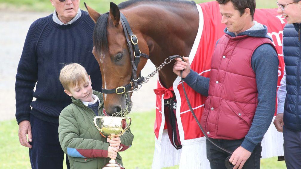 Rekindling eats from the Melbourne Cup trophy held aloft by Frank Williams