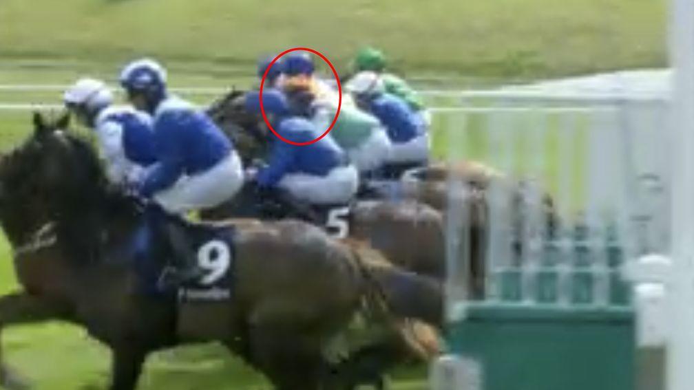 Ryan Moore's vision is obscured after the hood thrown by Kevin Stott accidentally lands on the jockey's head