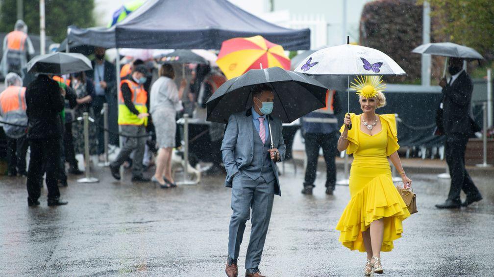 Racegoers arrive in the rain at Epsom on Oaks day