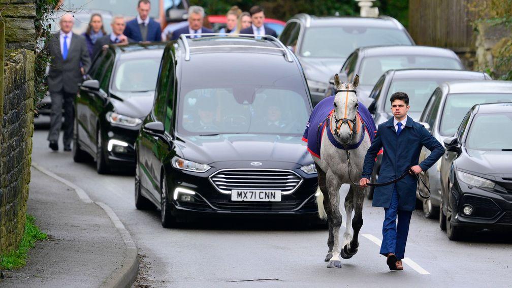 A hearse carrying jockey Keagan Kirkby makes its way to St Mary's Church, Ditcheat with Highland Hunter leading the way
