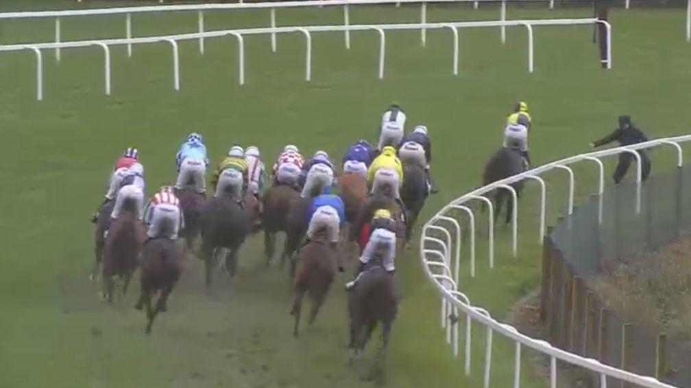 Narrow escape: an Ascot groundsman takes evasive action as the Sodexo Gold Cup field comes round the bend