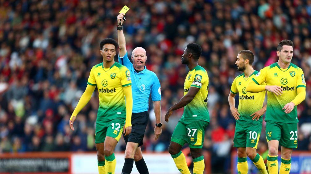 Lee Mason shows a yellow card to Jamal Lewis of Norwich City last month