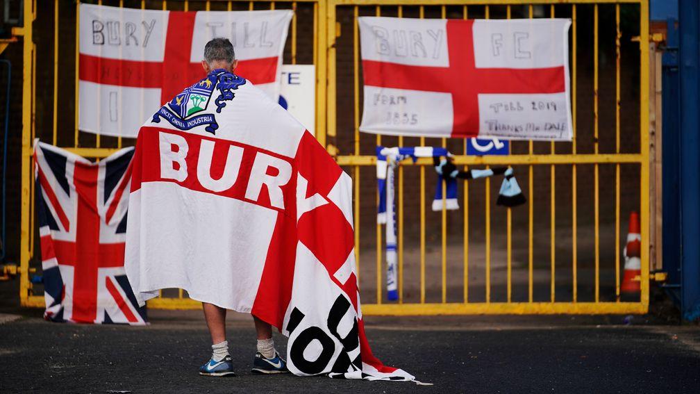 A Bury fan stands outside Gigg Lane in the week that the club were expelled from the EFL