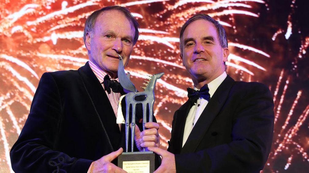 Gerry O'Brien, resplendent in blue smoking jacket (left), receives his award from John Osborne