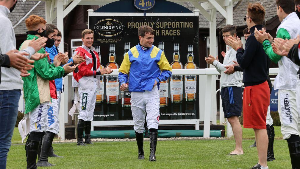 Brian Hughes receives a guard of honour at Perth last summer. The rider leads the way in his bid for a second jump jockeys' championship this season