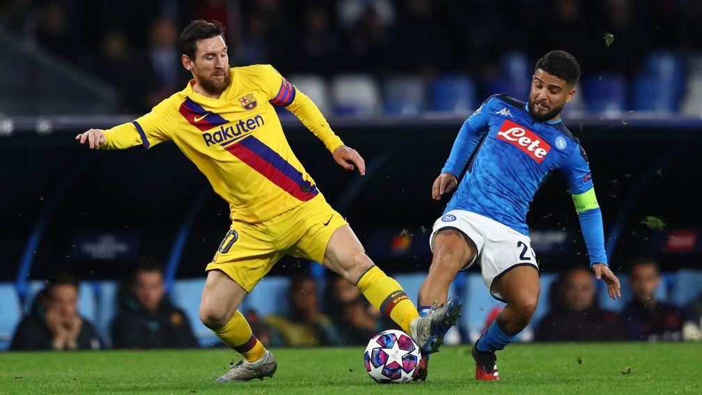 Lionel Messi holds off a challenge in the first leg against Napoli