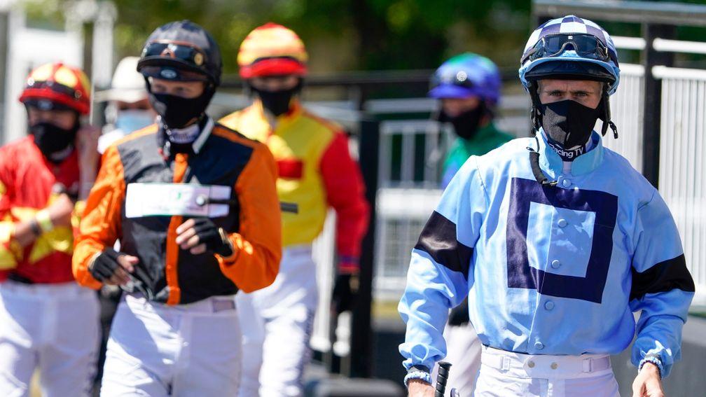 NEWCASTLE UPON TYNE, ENGLAND - JUNE 01: Paul Mulrennan (R) leads the jockeys to the parade ring at Newcastle Racecourse on June 01, 2020 in Newcastle upon Tyne, England. Horseracing resumes today for the first time since March 17th as the government relax