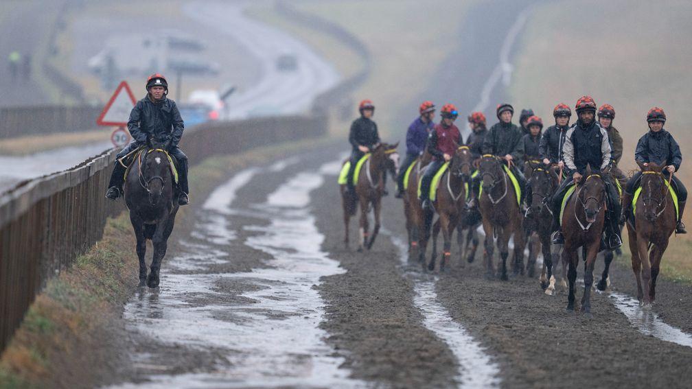 Torrential rain along with with thunder and lightning hits Newmarket as William Butler (L) , assistant to Sir Mark Prescott walks down Warren Hill with the string of horses from Heath House StablesNewmarket 25.8.22 Pic: Edward Whitaker
