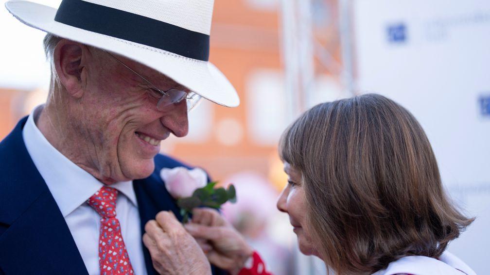 Lady Jane Cecil attaches a pink rose to John Gosden's lapel after Mighty Ulysses landed the Sir Henry Cecil Stakes at Newmarket