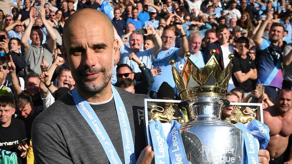 Manchester City manager Pep Guardiola poses with the Premier League trophy