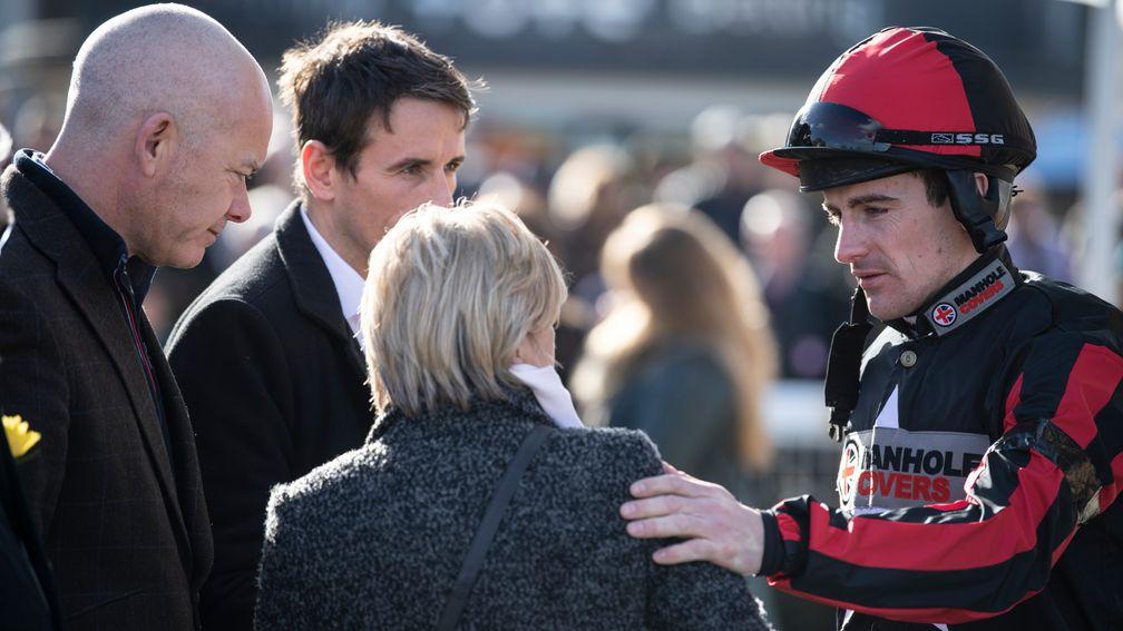 Leading jump jockey Brian Hughes consoles James Banks's mother Beveley Reid at Newbury on Saturday with PJA chief executive Paul Struthers (left)