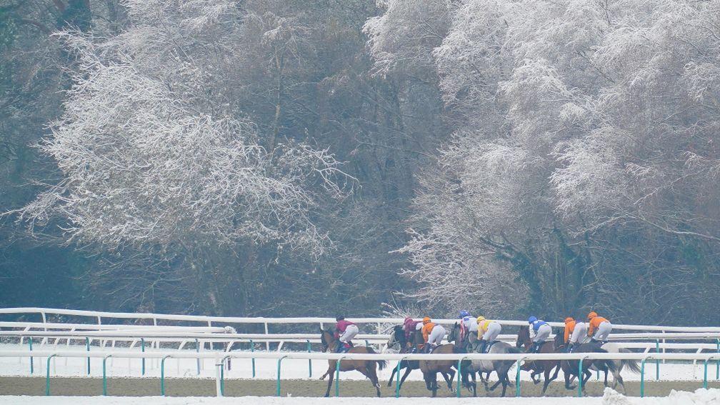 Runners in the opener a Lingfield make their way through a wintry landscape