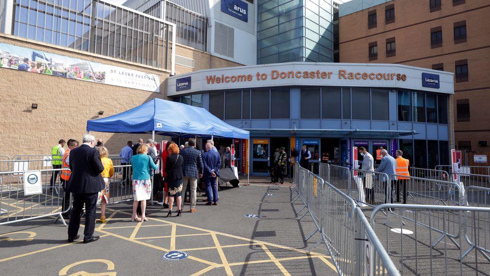 Racegoers queue to get into day one of the St Leger meeting at Doncaster in September - the trial proved short-lived and the public were not allowed in for the rest of the meeting