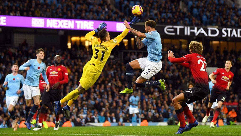 Manchester City goalie Ederson dives to make a save against United