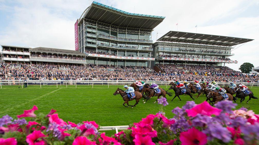 Packed stands for the start of the 2021 York Ebor festival as Copper Knight (blue) strikes