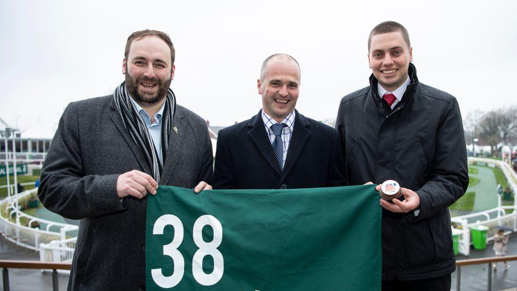 Competition winner Andrew George (left) and his brother Daniel (right) flank trainer David Dennis at Aintree