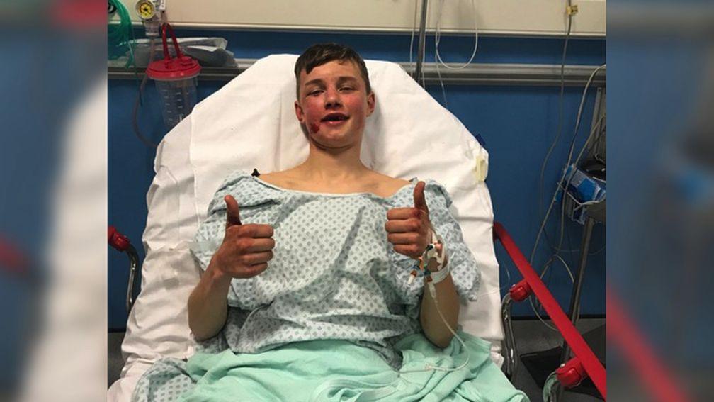 Injured jockey William Cox gives a thumbs up from his hospital bed