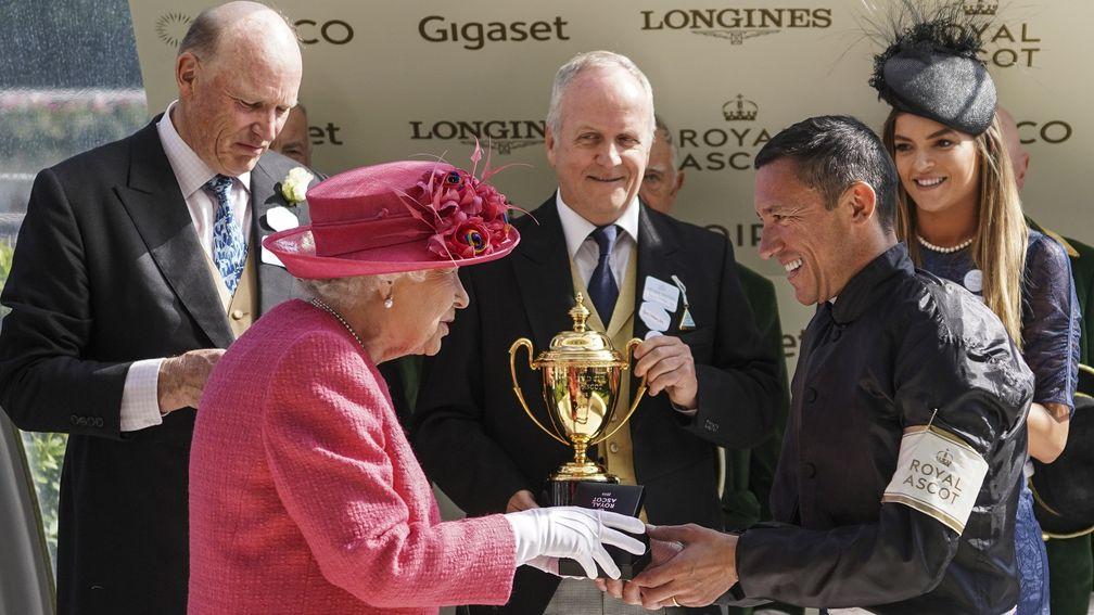 Proud owner Bjorn Nielsen (centre) holds the Ascot Gold Cup as HM The Queen greets Frankie Dettori after a memorable success