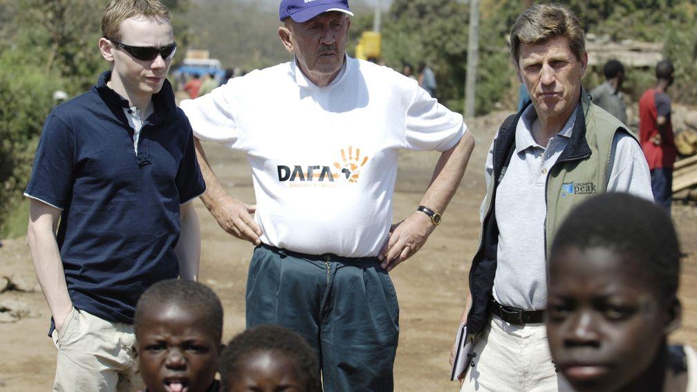 Jamie Spencer, Barney Curley and Brough Scott walk among children in Kantolomba shanty town in Zambia, 2006