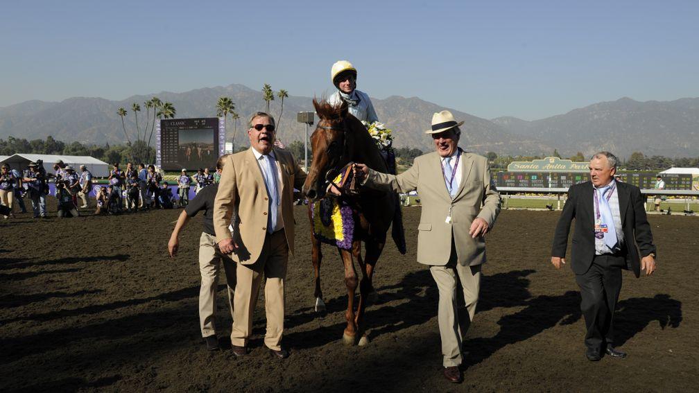 Sir Michael Stoute (left) and Peter Reynolds (second right) lead Conduit back to the winner's enclosure after his Breeders' Cup Turf victory