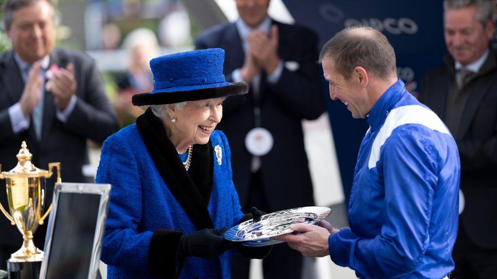 The Queen presents the jockey's trophy for the 2021 Queen Elizabeth II Stakes to Jim Crowley after Baaeed's success last year