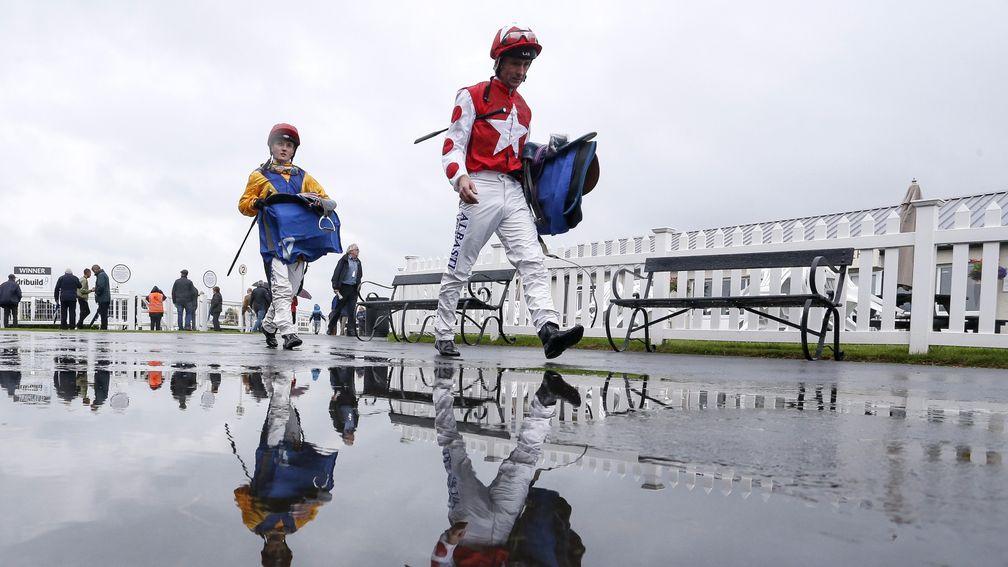 Jockeys return to the weighing room on a wet day at Bath on Wednesday