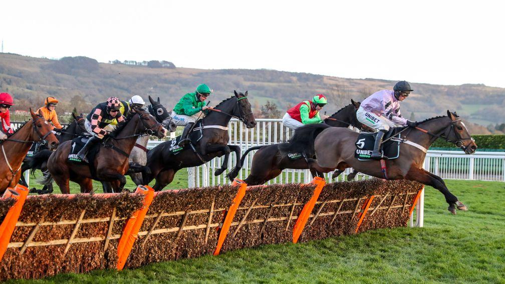 Call Me Lord (green silks) takes a flight of hurdles in third spot in the early stages of the International Hurdle