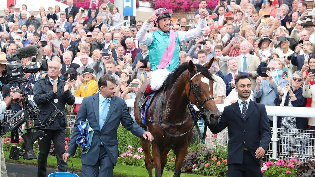 Enable groom Imran Shahwani (right) leads Enable back to the winner's enclosure after her tenth Group 1 success