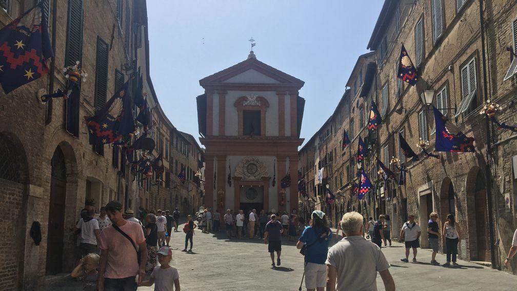 Flags of the Nicchio contrada hang from buildings in Siena ahead of the Palio