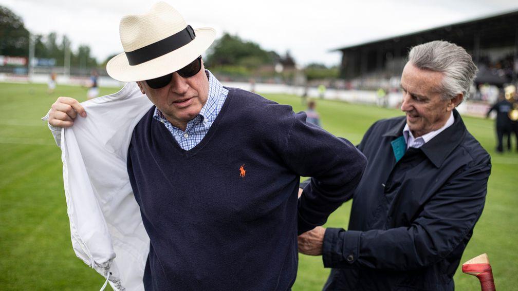 Rich Ricci gets a hand from Jim Bolger before going in as umpire at the 2019 Hurling For Cancer match
