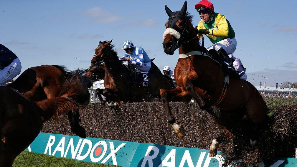 Bulldozer: Ploughing through a fence can't stop Fox Norton (right) from winning the Melling Chase