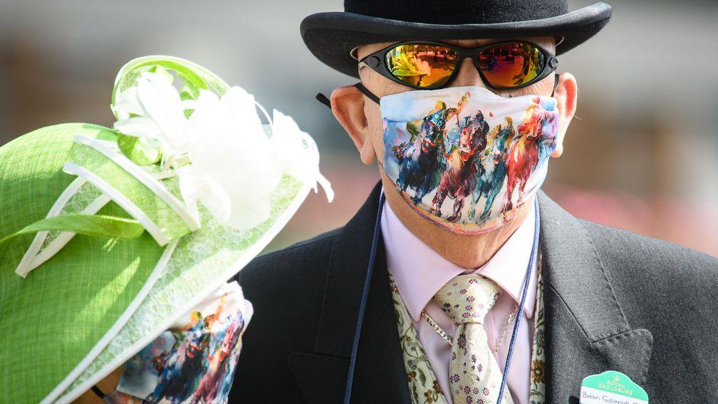 Racing-inspired face masks are sported by two racegoers