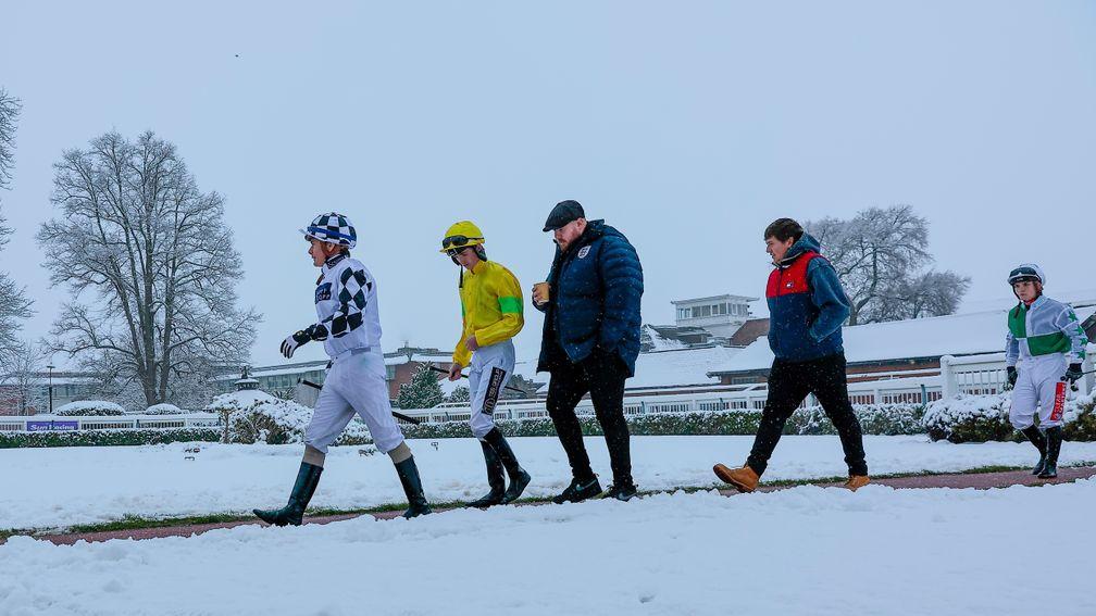 Jockeys walk out at a snowy Lingfield on Monday