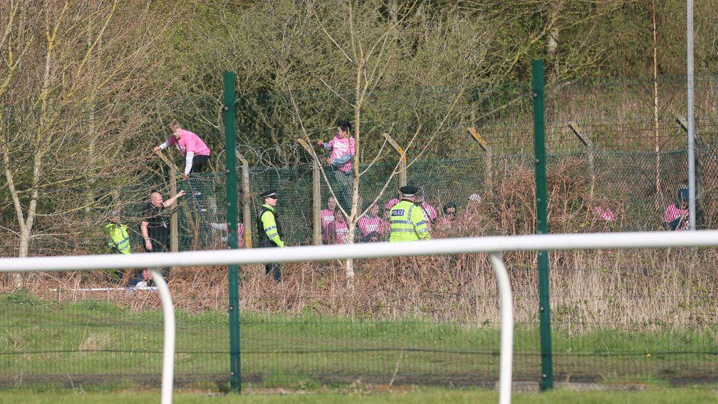 Protesters attempt to scale the fences at Aintree