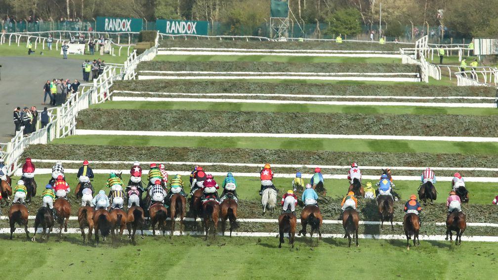 Crowding towards the inside rail as the field rise at the first fence in Saturday's Grand National.