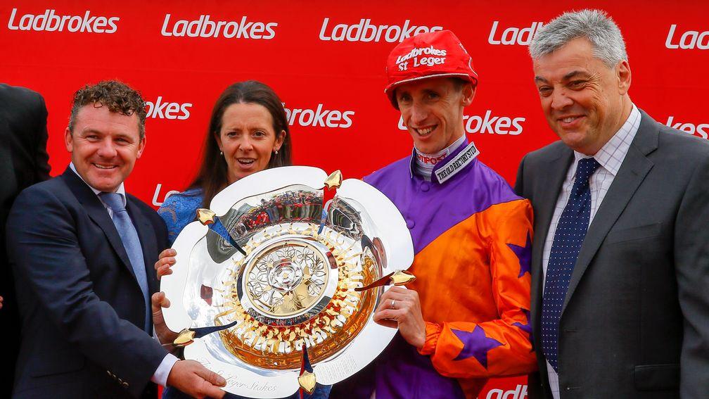 Happy days: George Baker celebrates winning the Ladbrokes St Leger on Harbour Law with trainer Laura Mongan and her husband Ian