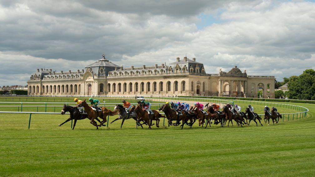 The field races around the bend at Chantilly against the backdrop of Les Grande Ecuries