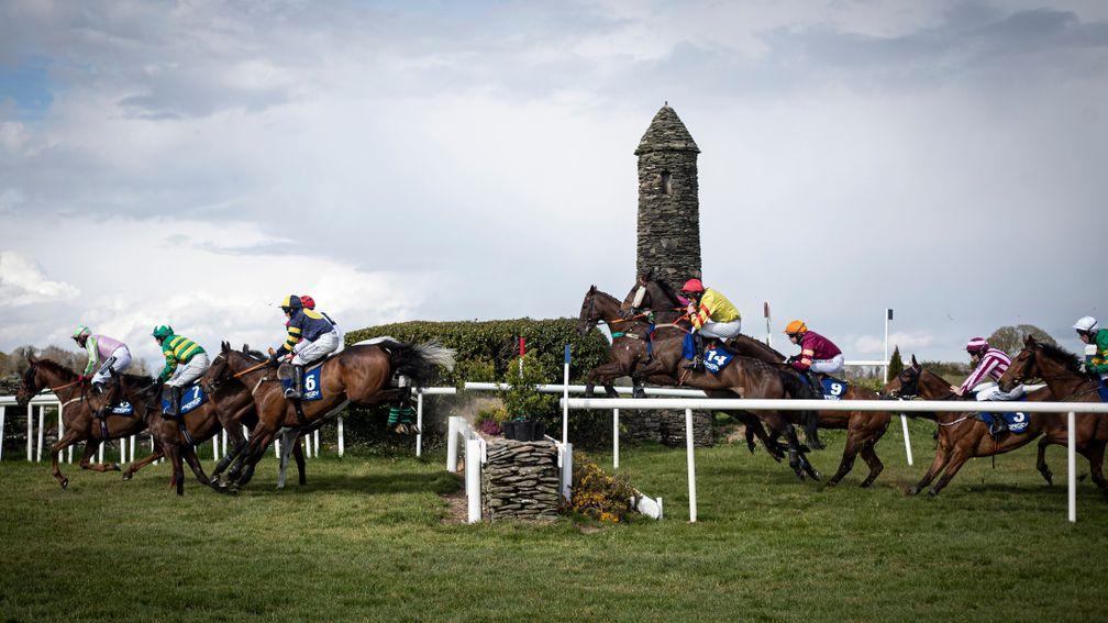Singing Banjo and Barry Walsh (yellow silks) get a good jump at the stone wall on their way to victory in the La Touche Cup