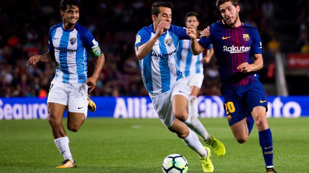 Malaga's Luis Hernandez tussels with Barcelona's Sergi Roberto