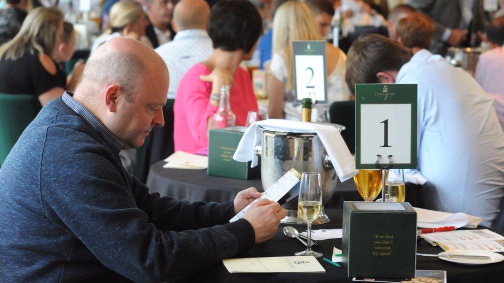 A restaurant diner studies the form over a glass of bubbly