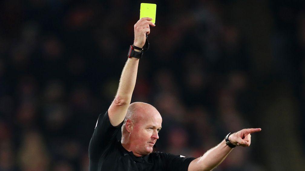 Referee Lee Mason awards a yellow card during the Premier League match between Sheffield United and Manchester City at Bramall Lane