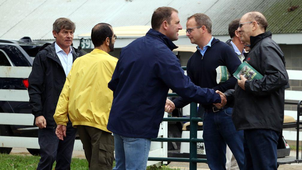 Sheikh Mohammed (yellow) and the Godolphin team exchange handshakes with Coolmore's MV Magnier and Michael Tabor