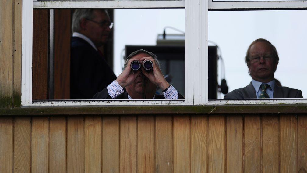 NEWMARKET, ENGLAND - JULY 12: A steward watches the action from the stewards box at Newmarket racecourse on July 12, 2014 in Newmarket, England. (Photo by Alan Crowhurst/Getty Images)