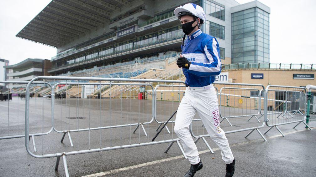 Keeping up the pace: champion jockey Oisin Murphy runs past deserted grandstands at Doncaster