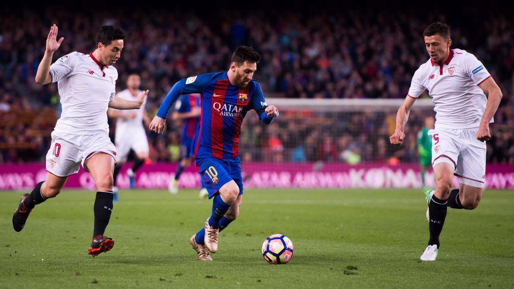Lionel Messi of Barcelona takes on Seville