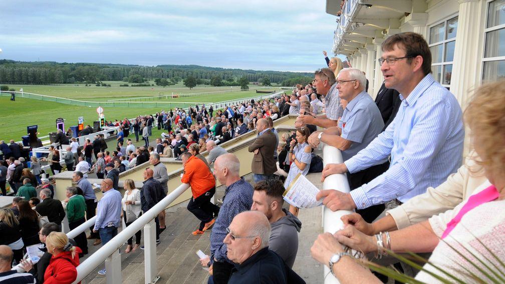 Racegoers watch the action from the restaurant balcony