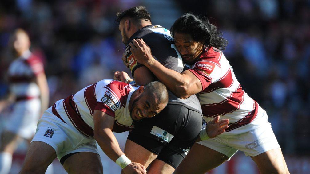 Willie Isa (left) and Taulima Tautai (R) of Wigan tackle Matt Cook of Castleford